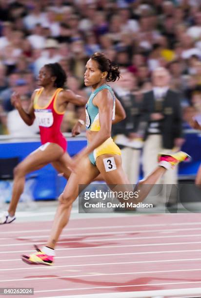 Cathy Freeman of Australia runs a first round heat of the Women's 400 meters event of the 2000 Summer Olympics track and field competition on...