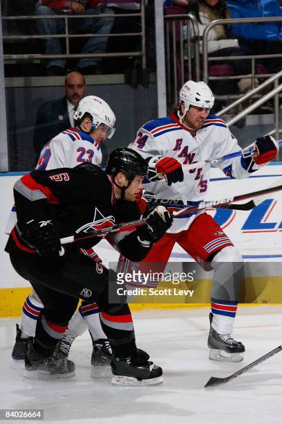 Aaron Voros of the New York Rangers skates against Tim Gleason of the Carolina Hurricanes on December 13, 2008 at Madison Square Garden in New York...