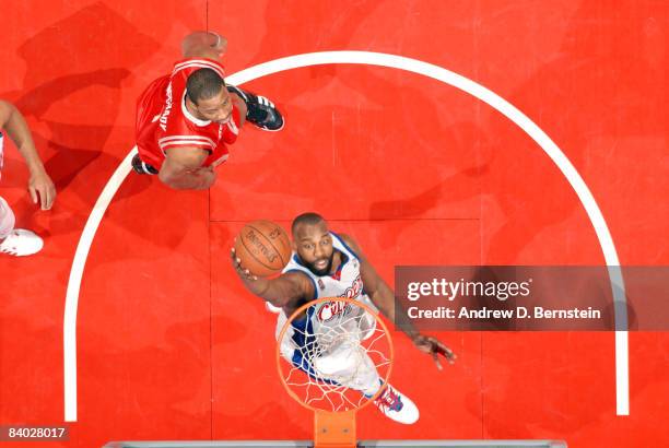 Baron Davis of the Los Angeles Clippers goes up for a shot while Tracy McGrady of the Houston Rockets looks on during their game at Staples Center on...