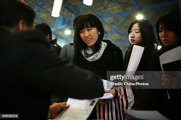 Job seekers hand in their resumes at a job fair for postgraduate students on December 14, 2008 in Beijing, China. Nearly 40,000 applicants competed...