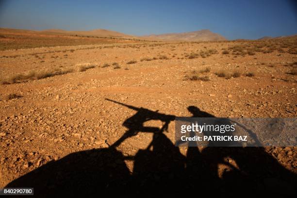 Picture taken on an army-organized press tour shows the silhouette of a Lebanese army soldier manning a machine gun on a hill they recently took from...