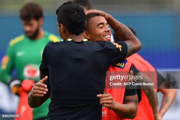 Brazil's team player Paulinho embraces Gabriel Jesus during a training session at the Gremio team training centre in Porto Alegre, Brazil on August...