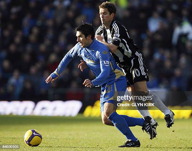 Portsmouth's Scottish Midfielder Richard Hughes vies with Newcastle's English Striker Michael Owen during their Premier League match against...