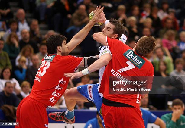 Guillaume Gille of Hamburg tries to score over Nenad Vuckovic and Thomas Klitgaard Melsungen compete for the ball during the Bundesliga match between...