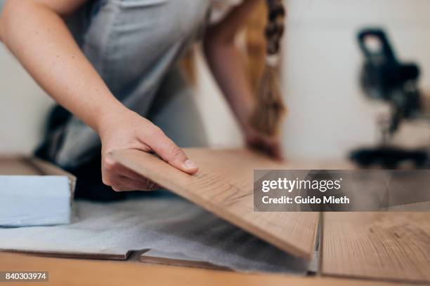 woman installing laminate flooring. - flooring stock-fotos und bilder