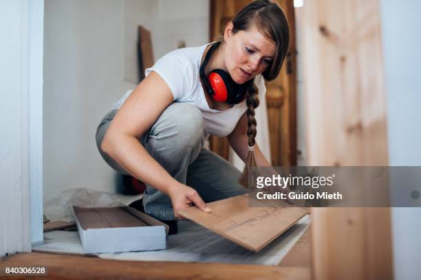 woman installing laminate flooring. - position fotografías e imágenes de stock