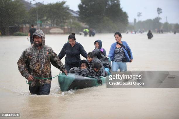People are rescued from a flooded neighborhood after it was inundated with rain water, remnants of Hurricane Harvey, on August 28, 2017 in Houston,...