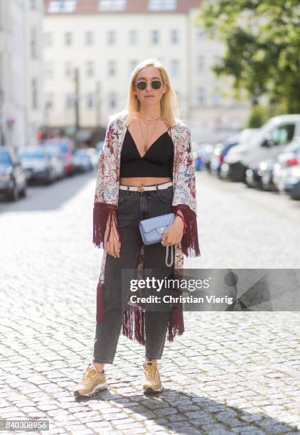 Sonia Lyson wearing a black cropped top, golden Nike Air Max sneakers, grey H&M mom jeans, blue Chanel bag, kimono with floral print Zara, Chanel,...