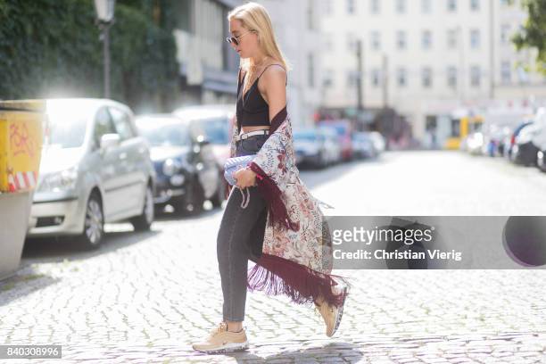 Sonia Lyson wearing a black cropped top, golden Nike Air Max sneakers, grey H&M mom jeans, blue Chanel bag, kimono with floral print Zara, Chanel,...