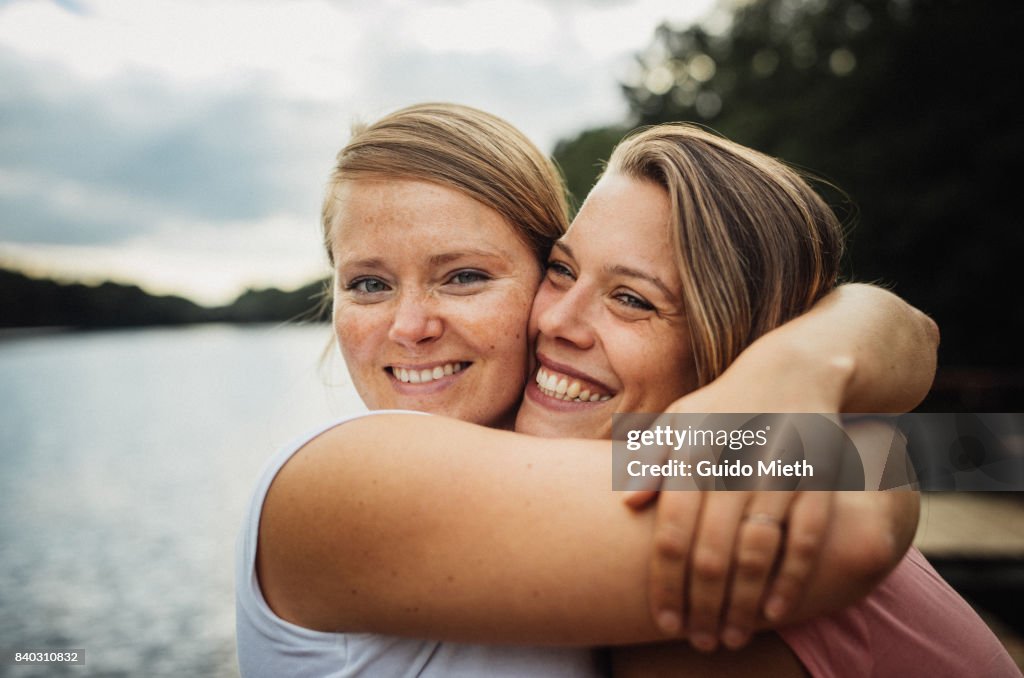 Smiling girlfriends hugging.