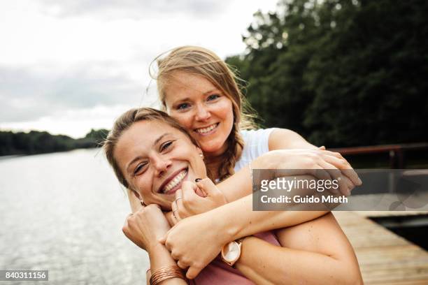 girlfriends hugging. - freundschaft stock-fotos und bilder