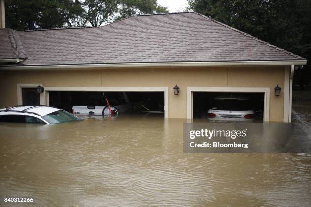 House and vehicles stand in floodwaters due to Hurricane Harvey in Spring, Texas, U.S., on Monday, Aug. 28, 2017. A deluge of rain and rising...