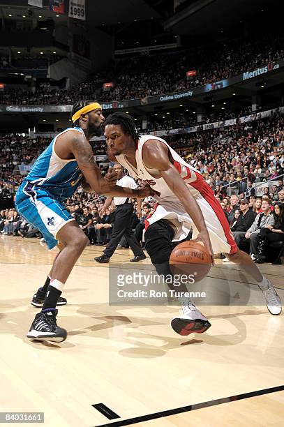 Chris Bosh of the Toronto Raptors drives baseline against Melvin Ely of the New Orleans Hornets on December 14, 2008 at the Air Canada Centre in...