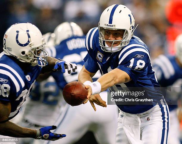 Quarterback Peyton Manning hands off to Dominic Rhodes of the Indianapolis Colts against the Detroit Lions on December 14, 2008 at Lucas Oil Stadium...