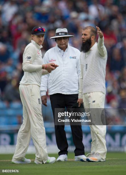 England's Joe Root and Moeen Ali in discussion with Sundaram Ravi during the second day of the second test between England and West Indies at...