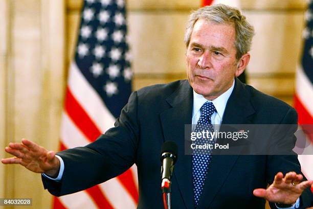 President George W. Bush reacts to calm the situation after a shoe was thrown by a reporter during a joint press conference Iraqi Prime Minister Nuri...