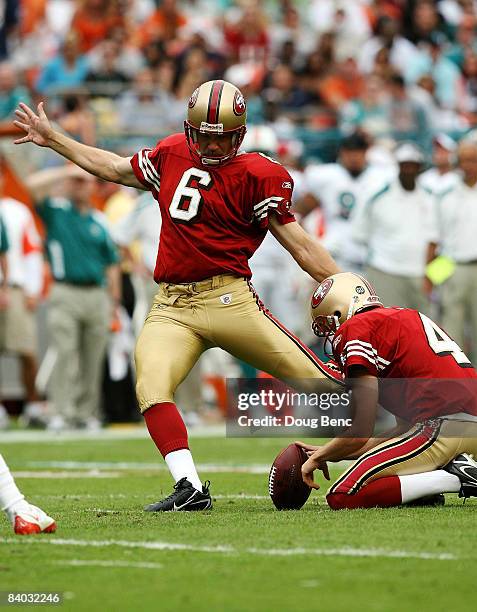 Place kicker Joe Nedney of the San Francisco 49ers kicks a field goal out from under the hold of punter Andy Lee while taking on the Miami Dolphins...