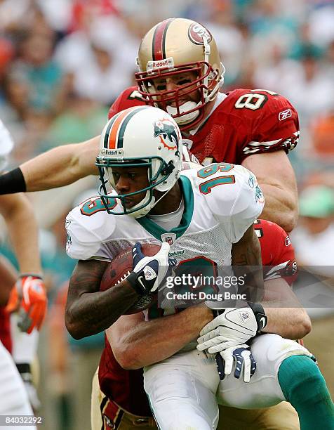 Billy Bajema and Sean Ryan of the San Francisco 49ers bring down Ted Ginn Jr. #19 of the Miami Dolphins on a kick return at Dolphin Stadium on...