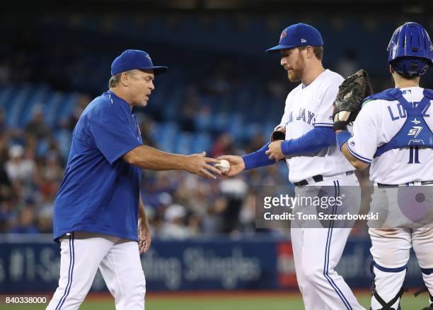 Danny Barnes of the Toronto Blue Jays exits the game as he is relieved by manager John Gibbons in the seventh inning during MLB game action against...