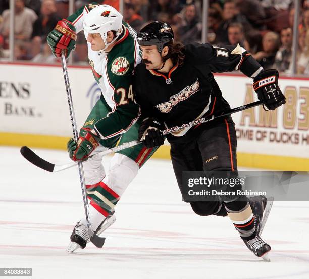 Derek Boogaard of the Minnesota Wild fights for position against George Parros of the Anaheim Ducks during the game on December 14, 2008 at Honda...