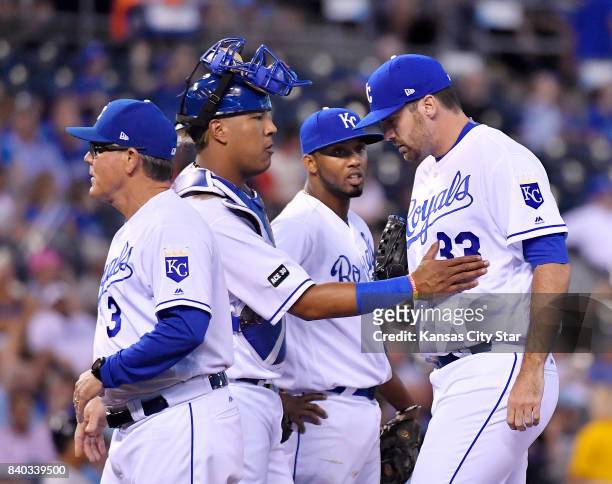 Kansas City Royals catcher Salvador Perez gives relief pitcher Brian Flynn a pat on the chest after manager Ned Yost relieved starting pitcher Ian...