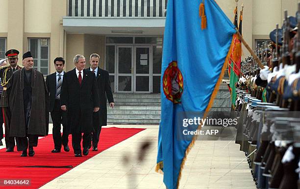 Afghan President Hamid Karzai and US President George W. Bush inspect a guard of honour prior to a meeting at the Presidential Palace in Kabul on...