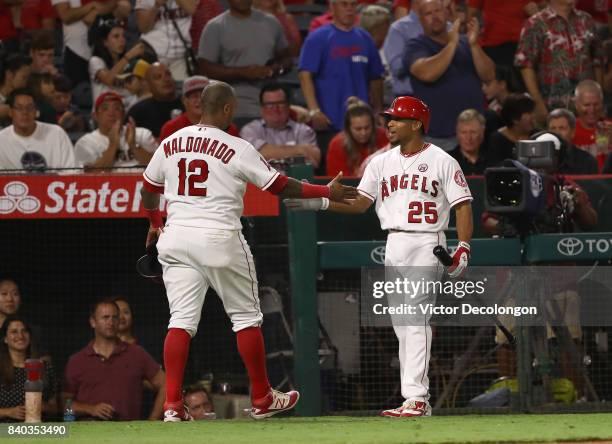 Martin Maldonado and Ben Revere of the Los Angeles Angels of Anaheim celebrate after Maldonado scored during the fourth inning of the MLB game...