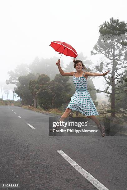 girl on street  jumping with red umbrella - philipp nemenz stock-fotos und bilder