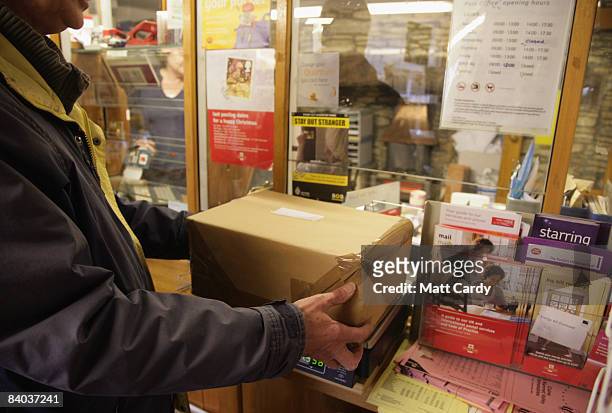 Customers weigh packages inside the historic Lacock Village Stores and Post Office on December 15 2008 in Lacock, United Kingdom. Post Offices across...