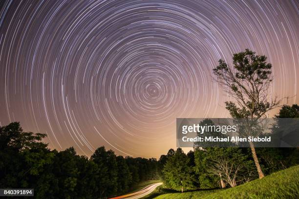 star trail with headlight trail centered on polaris - natchez trace parkway stock pictures, royalty-free photos & images
