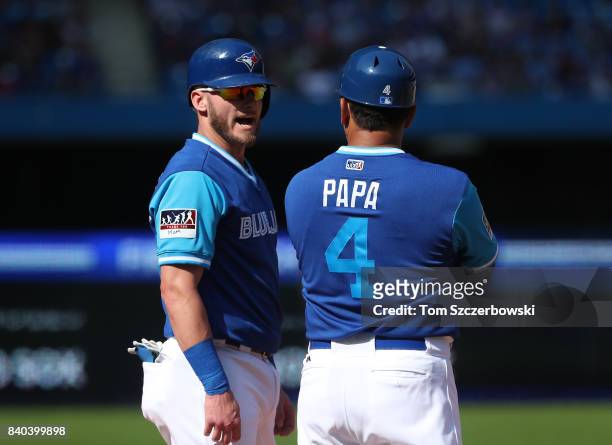 Josh Donaldson of the Toronto Blue Jays talks to third base coach Luis Rivera as he stands on third base in the eighth inning during MLB game action...