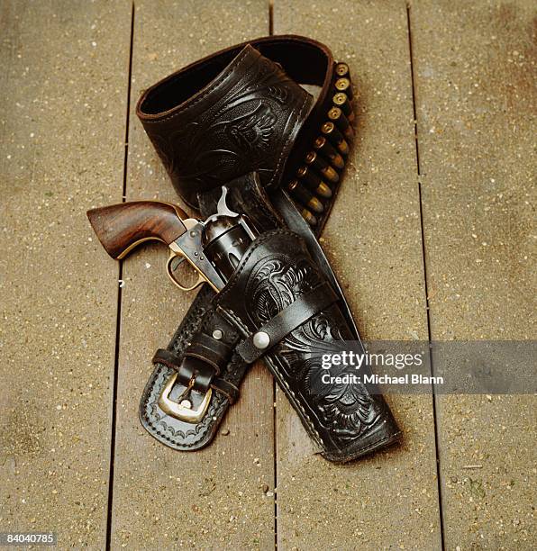 gun with holster and bullets on wooden floor - gun stock pictures, royalty-free photos & images