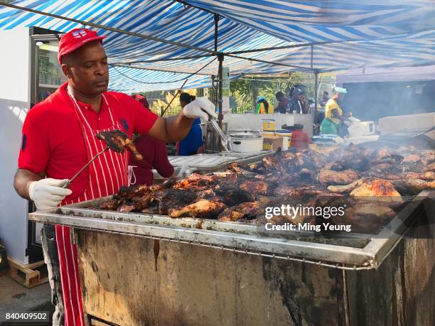 Cook prepares the carnival favourite jerk chicken on the BBQ at Notting Hill Carnival on August 27, 2017 in London, England.