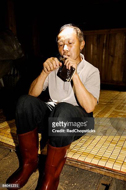 senior man lighting a cigar, jinkeng terraced field, guangxi province, china - glatze drogenabhängig stock-fotos und bilder