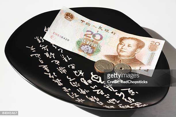 chinese yuan note and chinese coins in a plate - 20 yuan note stock pictures, royalty-free photos & images