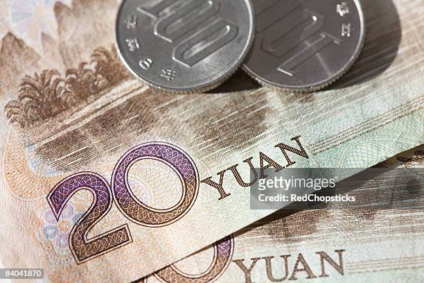 close-up of coins on chinese paper currency - 20 yuan note stock pictures, royalty-free photos & images