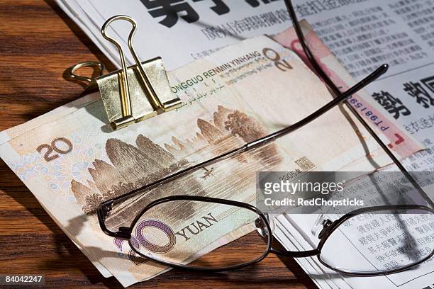 eyeglasses and chinese yuan note on a newspaper - 20 yuan note stock pictures, royalty-free photos & images