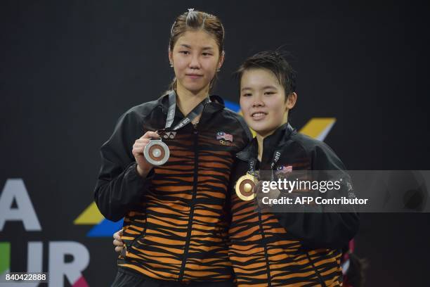 Gold medallist Goh Jin Wei and silver medallist Soniia Cheah of Malaysia pose with their medals after the women's singles badminton final at the 29th...