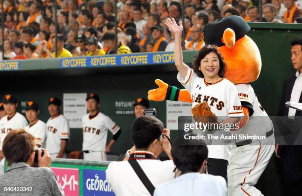 Internal Affairs and Communications Minister Seiko Noda waves to crowd before throwing the memorial first pitch prior to the game between Yomiuri...