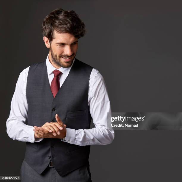 happy businessman standing with hands clasped - waistcoat stock pictures, royalty-free photos & images