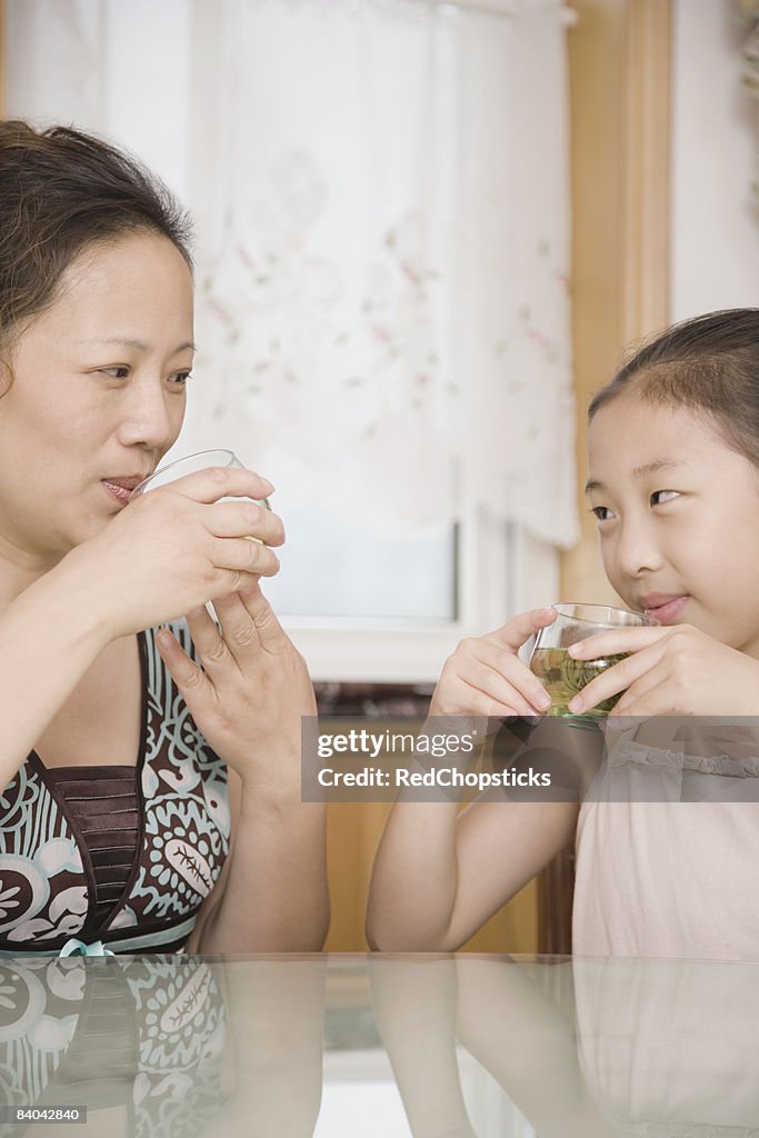 Mature woman with her daughter drinking tea