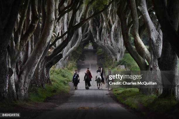 Four actors on horseback dressed in Game of Thrones related costumes carry the Queen's Baton as they make their way way along the Dark Hedges on...