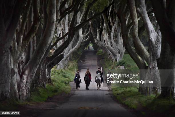 Four actors on horseback dressed in Game of Thrones related costumes carry the Queen's Baton as they make their way way along the Dark Hedges on...