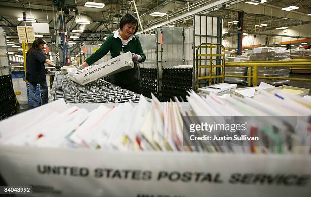 Postal worker Tin Aung moves boxes of letters and cards at the U.S. Post Office sort center December 15, 2008 in San Francisco, California. On its...