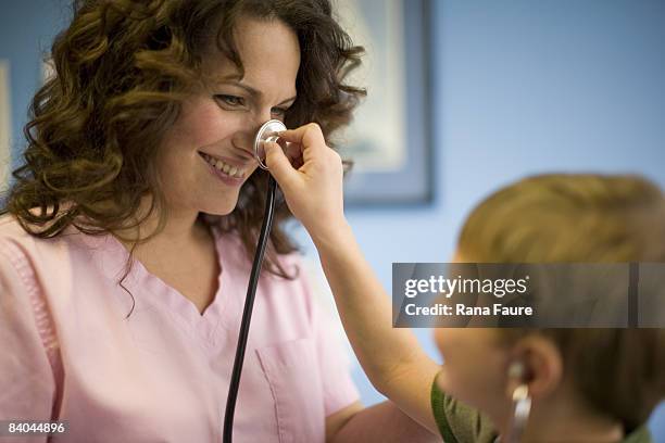 pediatric's office nurse with patients - naughty nurse images stock-fotos und bilder