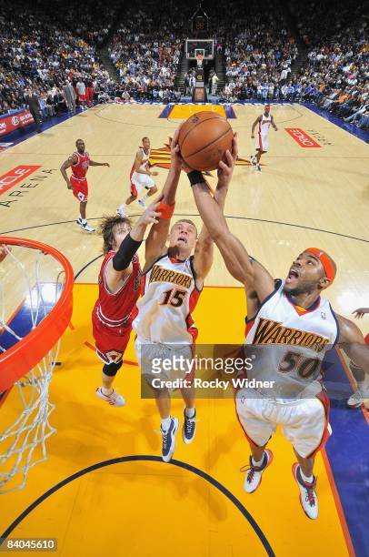 Andris Biedrins and Corey Maggette of the Golden State Warriors go after a rebound against Andres Nocioni of the Chicago Bulls during the game on...
