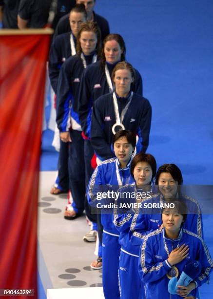 Members of the Chinese team and of the US team are pictured on the podium of the 4X100m medley relay event, 26 July 2003 in Barcelona, at the 10th...