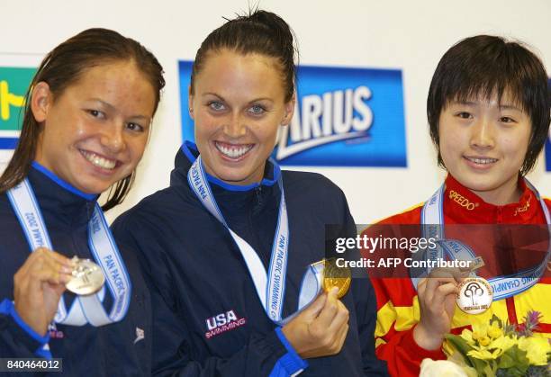 Accompanied by second-placed Tara Kirk of USA and third-placed Xuejuan Luo of China, Amanda Beard of USA shows her gold medal during an awarding...