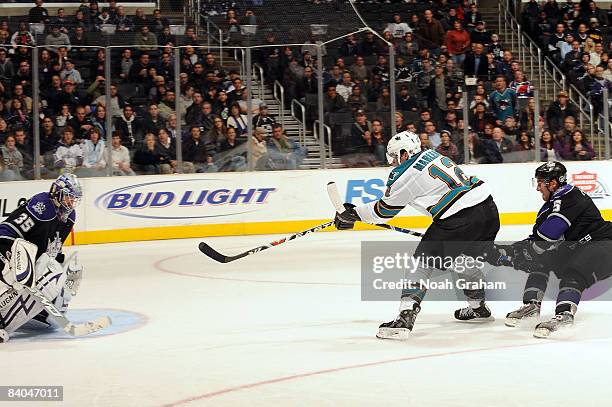 Patrick Marleau of the San Jose Sharks makes a shot on goal as Jason LaBarbera and Peter Harrold of the Los Angeles Kings defend during the game on...