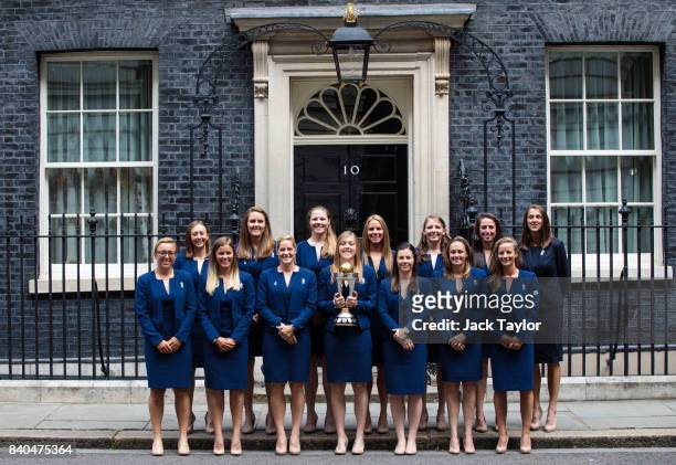 England women's cricket team captain Heather Knight holds the ICC Women's World Cup Cricket trophy as she poses with teammates before attending a...